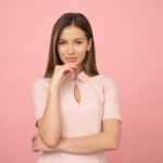 A girl smiling amid a pink background